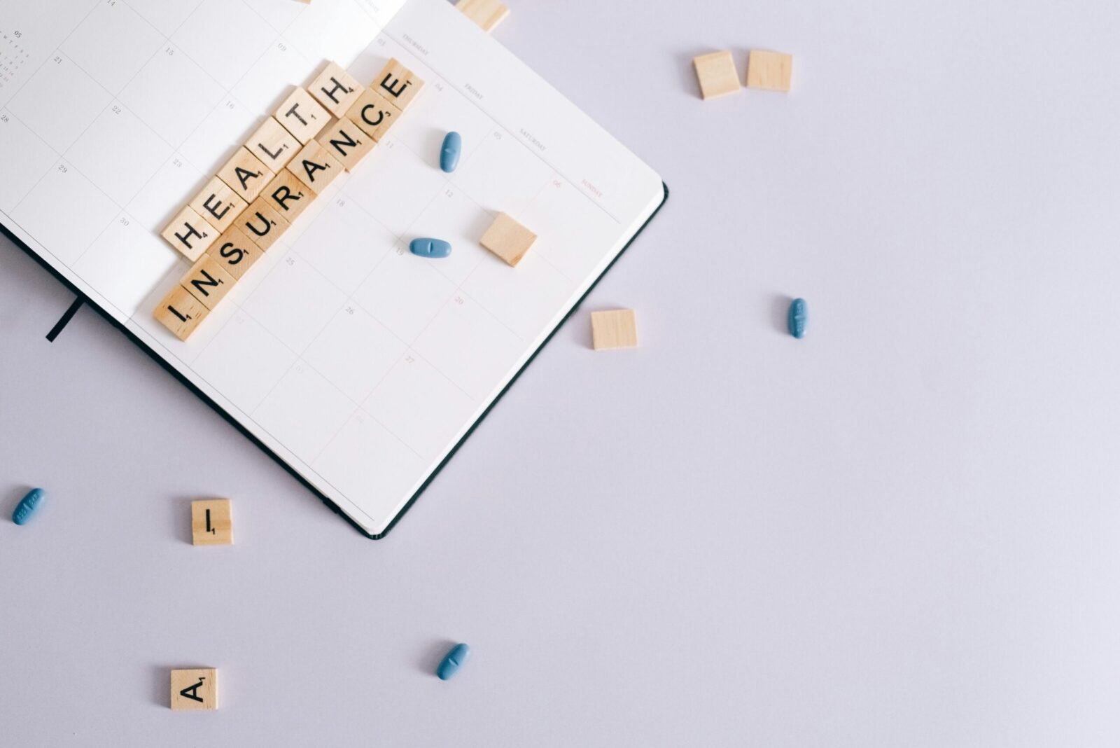 Flat lay of health insurance concept with planner and pills.